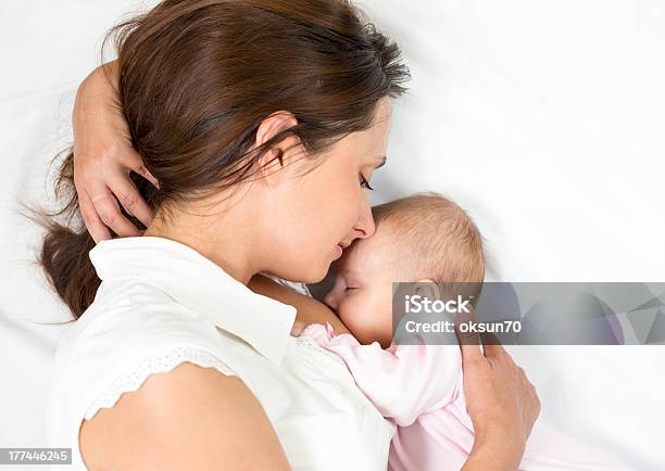 Mother Breastfeeding Infant Daughter While Lying Down Stock Photo - Download Image Now