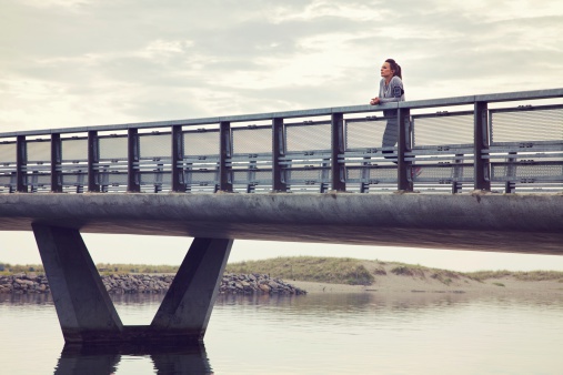 Woman alone on the bridge against cloudy sky