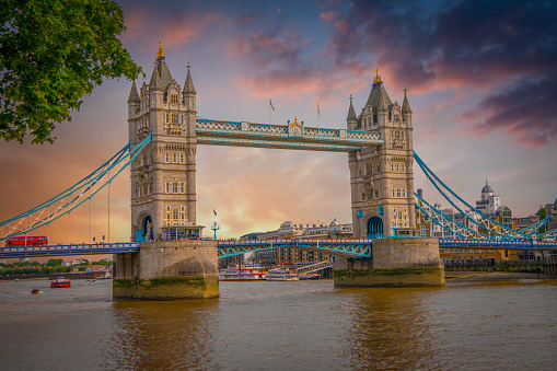 An evening view of the floodlit Tower of London from across the Thames at dusk.