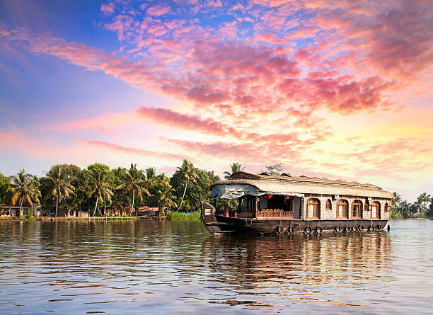 House boat in backwaters House boat in backwaters near palms at dramatic sunset sky in alappuzha, Kerala, India kerala south india stock pictures, royalty-free photos & images