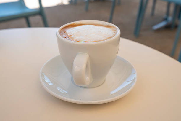 White cup of delicious cappuccino on table. High quality photo