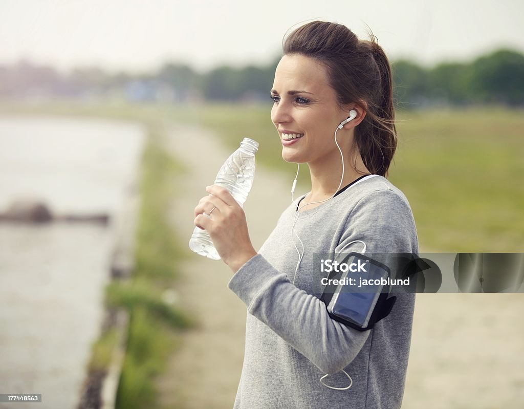 Kobieta Biegacz Trzymając butelkę wody - Zbiór zdjęć royalty-free (20-24 lata)