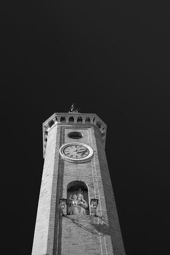 The 19th century brick clock tower in the historical center of Comacchio near Ferrara in Emilia Romagna, Italy