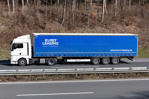 Wiehl, Germany - March 24, 2021: MAN TGX truck with Euro Leasing curtainside trailer on motorway