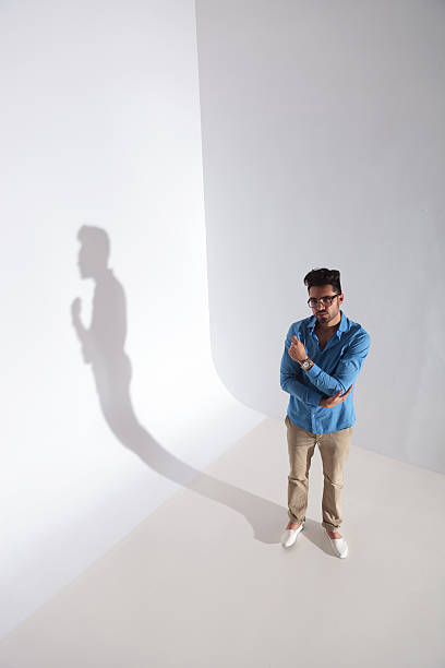 istock casual man looks up with hands crossed 177451443