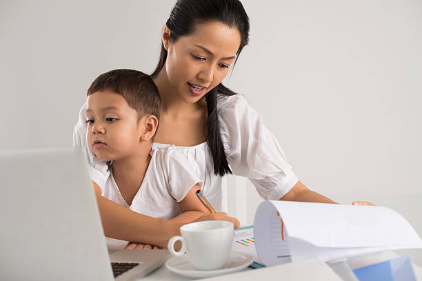 istock A little boy helping his mom do her homework 177451566
