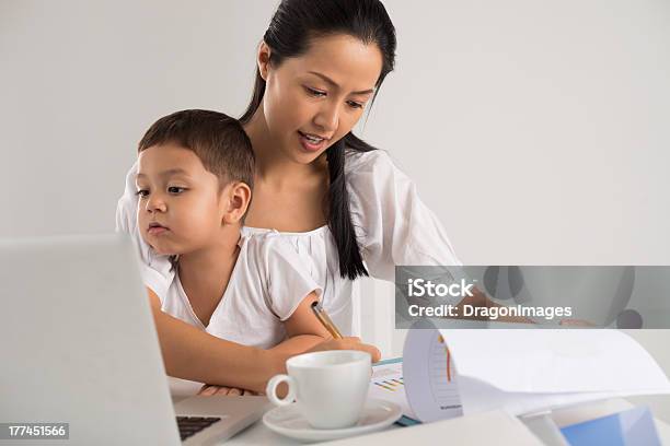A Little Boy Helping His Mom Do Her Homework Stock Photo - Download Image Now - Asian and Indian Ethnicities, Multi-Tasking, Women