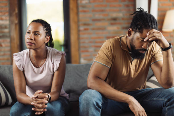 Angry African American couple ignoring each other at home