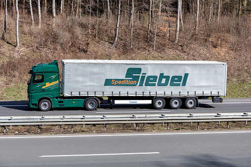 Wiehl, Germany - March 24, 2021: Spedition Siebel Mercedes-Benz Actros truck with curtainside trailer on motorway
