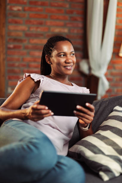 istock African American woman using touchpad while relaxing at home 1774525384