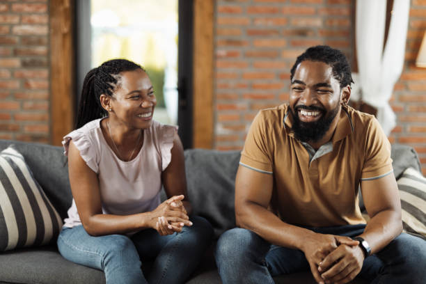 istock Happy black couple talking while  relaxing  on sofa at home 1774536143