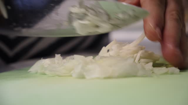 Cutting slicing onion on the table, close up. Cooking process, chopping onions for frying