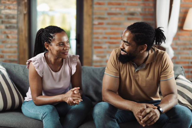 Young African American couple talking on sofa in the living room