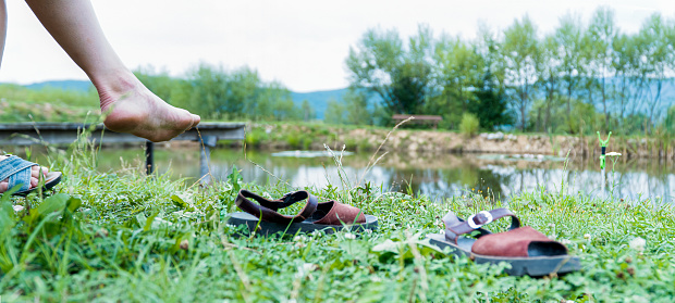 Women's feet resting on the shore of the lake. People nature serenity. relaxation in nature