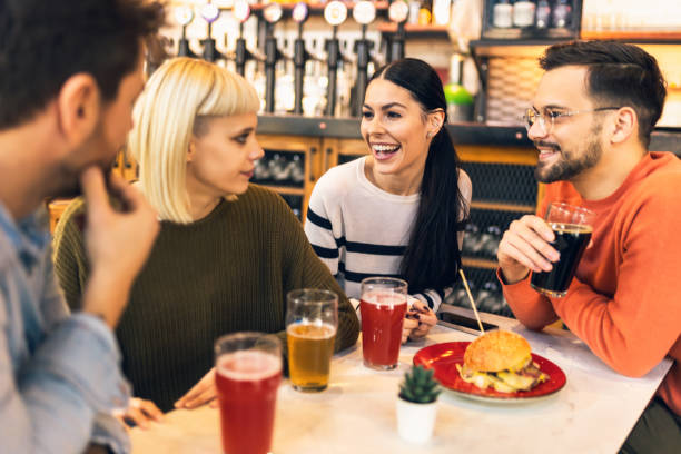 istock Smiling young friends drinking craft beer in pub 1774542570