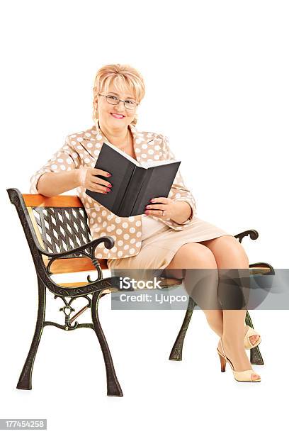 Madura Mulher Sentada No Banco E Ler Um Livro - Fotografias de stock e mais imagens de Adulto - Adulto, Adulto maduro, Banco - Assento