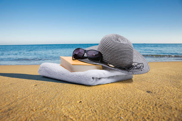 istock Book, towel, sunglasses and sun hat on the beach 1774543684