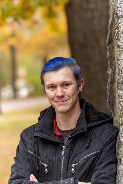 istock Caucasian, blue-haired young man posing in a park in autumn 1774543926