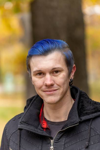 istock Caucasian, blue-haired young man posing in a park in autumn 1774543927