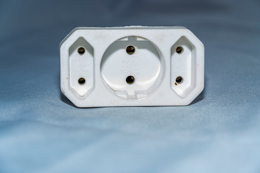 White three-pin socket adapter on white background