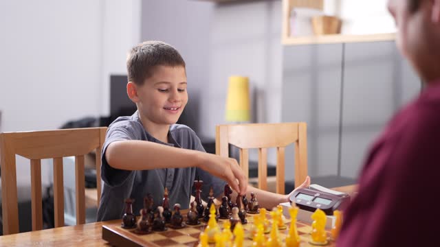 Boy playing chess with big brother