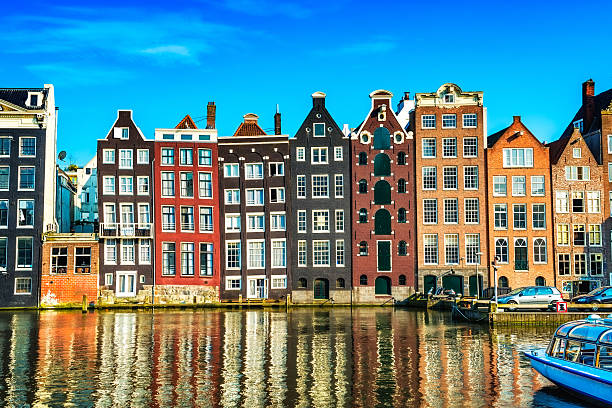 typical gabled dutch houses on a canal in central amsterdam - amsterdam stockfoto's en -beelden