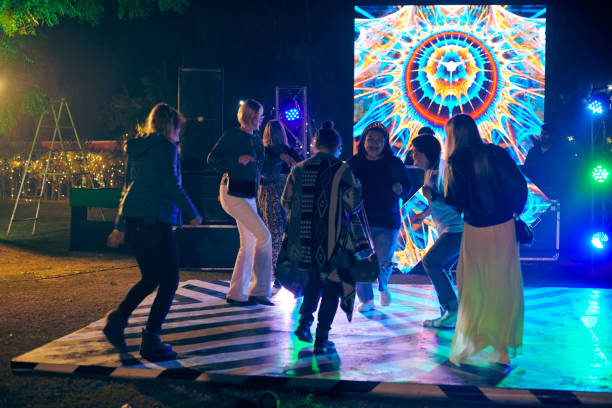 drôles de gens dansant la nuit sur la piste de danse en plein air avec fond de projecteurs multicolores - indian culture dancing dancer women photos et images de collection