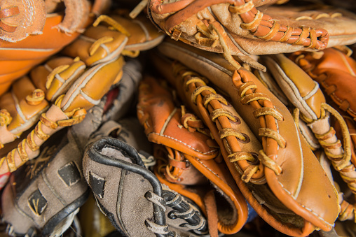 Old baseball gloves forgotten in a corner of a baseball academy.