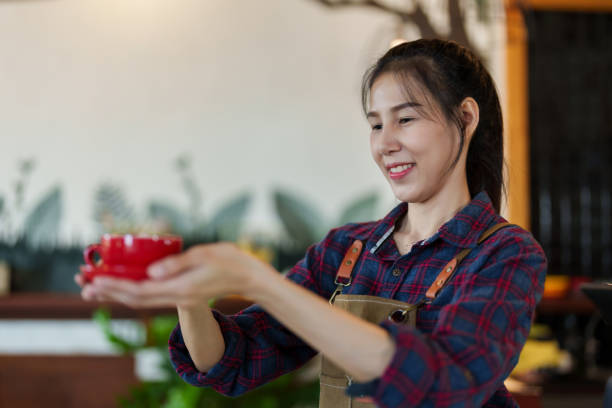 Cafe owner businessman employee beautiful Asian woman cute she smiles holding red coffee cup Take photos from side to promote your coffee shop welcome customers cafe small business Minimal style shop dueño de la cafetería, hombre de negocios, empleado, hermosa mujer asiática, linda, sonríe, sosteniendo una taza de café roja, tome fotos desde el lado para promocionar su cafetería, dé la bienvenida a los clientes, cafetería, pequeña empresa tien