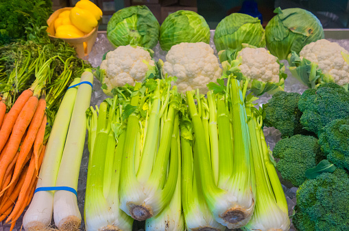 Fresh vegetables, neatly arranged on a bed of ice at a late season indoor farmers market on Cape Cod include carrots, yellow peppers, leeks, celery, broccoli, cauliflower and cabbage