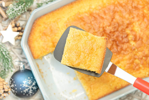 Homemade baked side dish of a cheesy cornbread made with cream-style corn, dry cornbread mix, sour cream, buttermilk, melted butter, eggs and sugar for a Christmas side dish