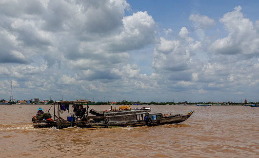 Mekong River, Tien Giang, Vietnam-September 8, 2018: Fisherman a small boat preparing nets while moving across the Mekong River Delta, Vietnam.