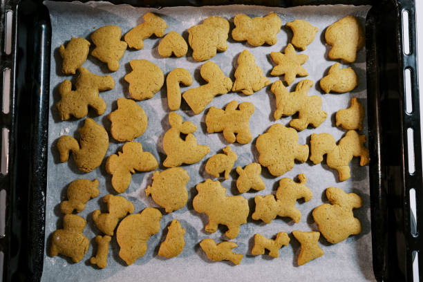 i biscotti di natale appena sfornati giacciono su carta da forno su una teglia. vista dall'alto - 5549 foto e immagini stock