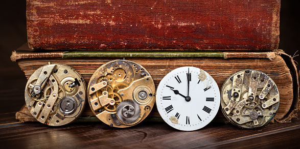 Antique clockworks and clock face with old books. Time machine banner, background. Hours and minutes.