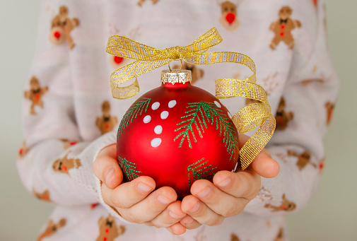 Close up of children hands holding Christmas bauble. Children hands holding Christmas bauble