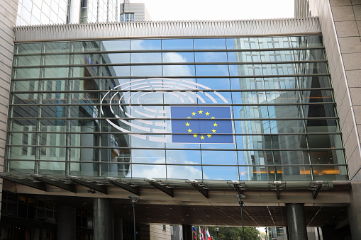 Brussels, B, Belgium - August 18, 2022: HEadquartiers of the European Parliament and the flag with yellow stars
