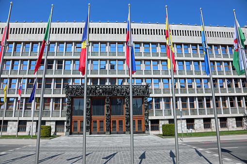 Ljubljana, L, Slovenia - August 15, 2023: Slovenian Parliament Building of the European capital and many flags without people