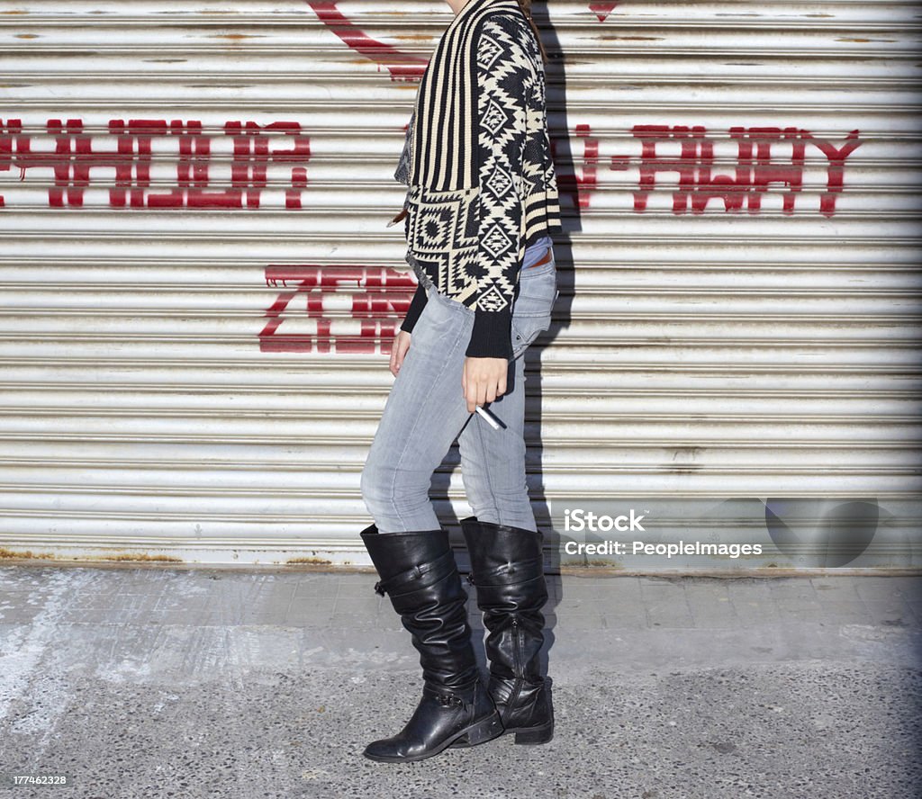 Way too cool! A cropped shot of a young girl carrying a cigarette in front of a corrugated iron wall Cigarette Stock Photo