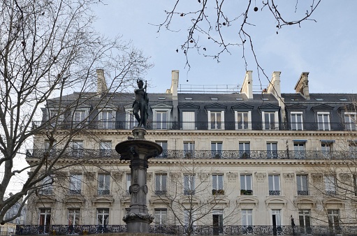 Iron Sculpture in front of beautiful residential building in Paris, France.