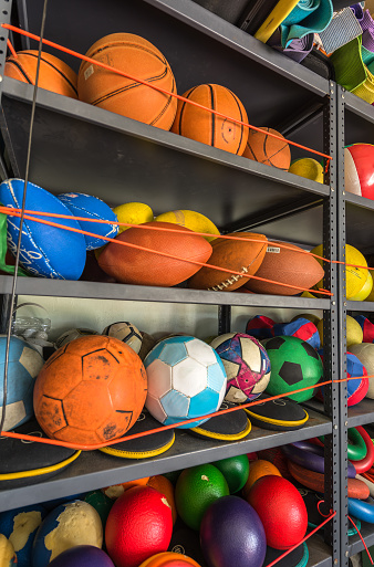 Colorful shelf full of balls from different sports.