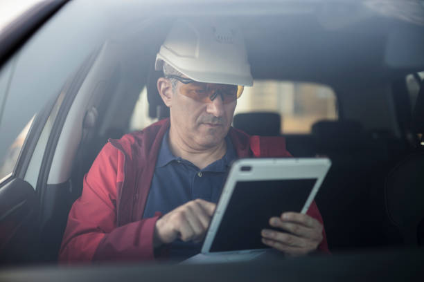 istock Male engineer sitting in vehicle and using his tablet PC 1774647526