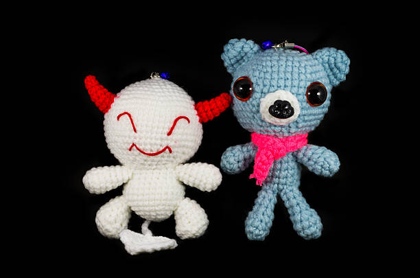 istock handmade crochet white devil and dog doll on black background 177464873