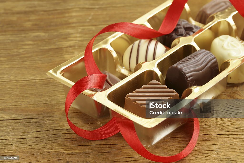 Scatola regalo di caramelle al cioccolato su sfondo in legno - Foto stock royalty-free di Amore