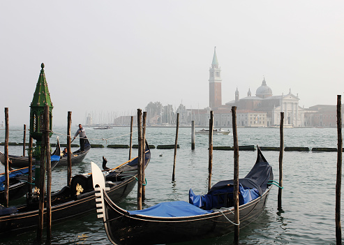 Venice, Italy, October 13, 2017: Gondolas in Venice on a foggy day.
