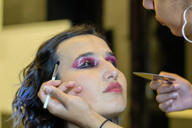 istock young woman applying make up (paint her eyelashes) for a evening date in front of a mirror. Focus on her reflection 1774686368