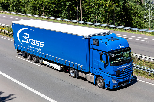 Wiehl, Germany - June 26, 2020: Brass Mercedes-Benz Actros truck with curtainside trailer on motorway
