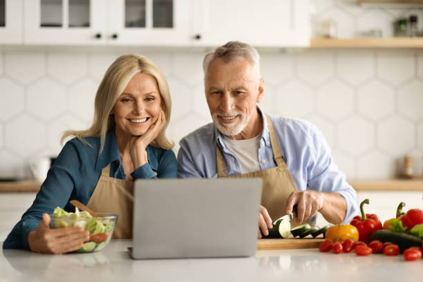 istock Smiling Elderly Spouses Looking Recipe On Laptop While Cooking Food In Kitchen 1774702903
