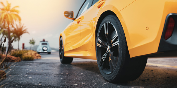 A yellow car is parked on the side of the road by the sea. The sky is clear. 3d, rendering, illustration,