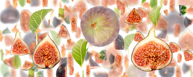 Abstract background made of Fig fruit pieces, slices and leaves isolated on white.
