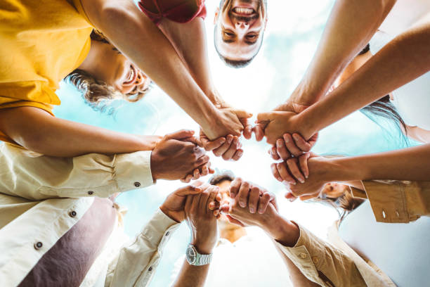 istock Multi ethnic group of young people holding hands outdoors - Community life style concept with guys and girls hugging together outside - Unity, support and collaboration concept 1774790002